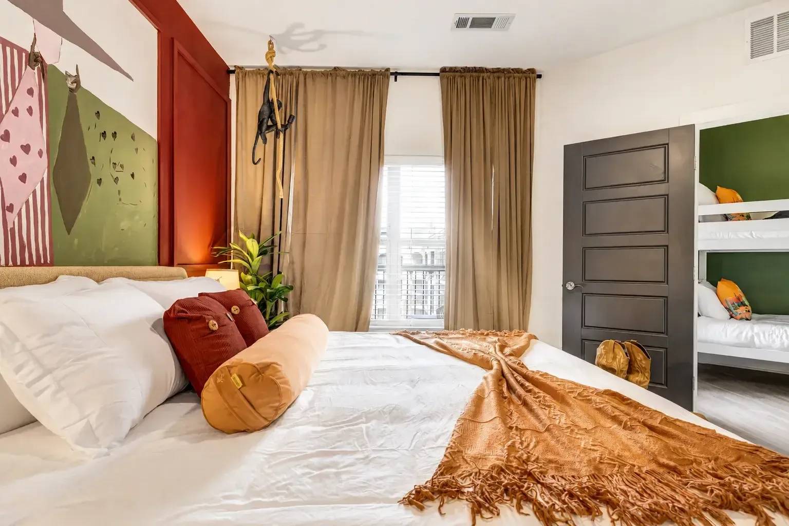 Bright bedroom with king bed and draped windows