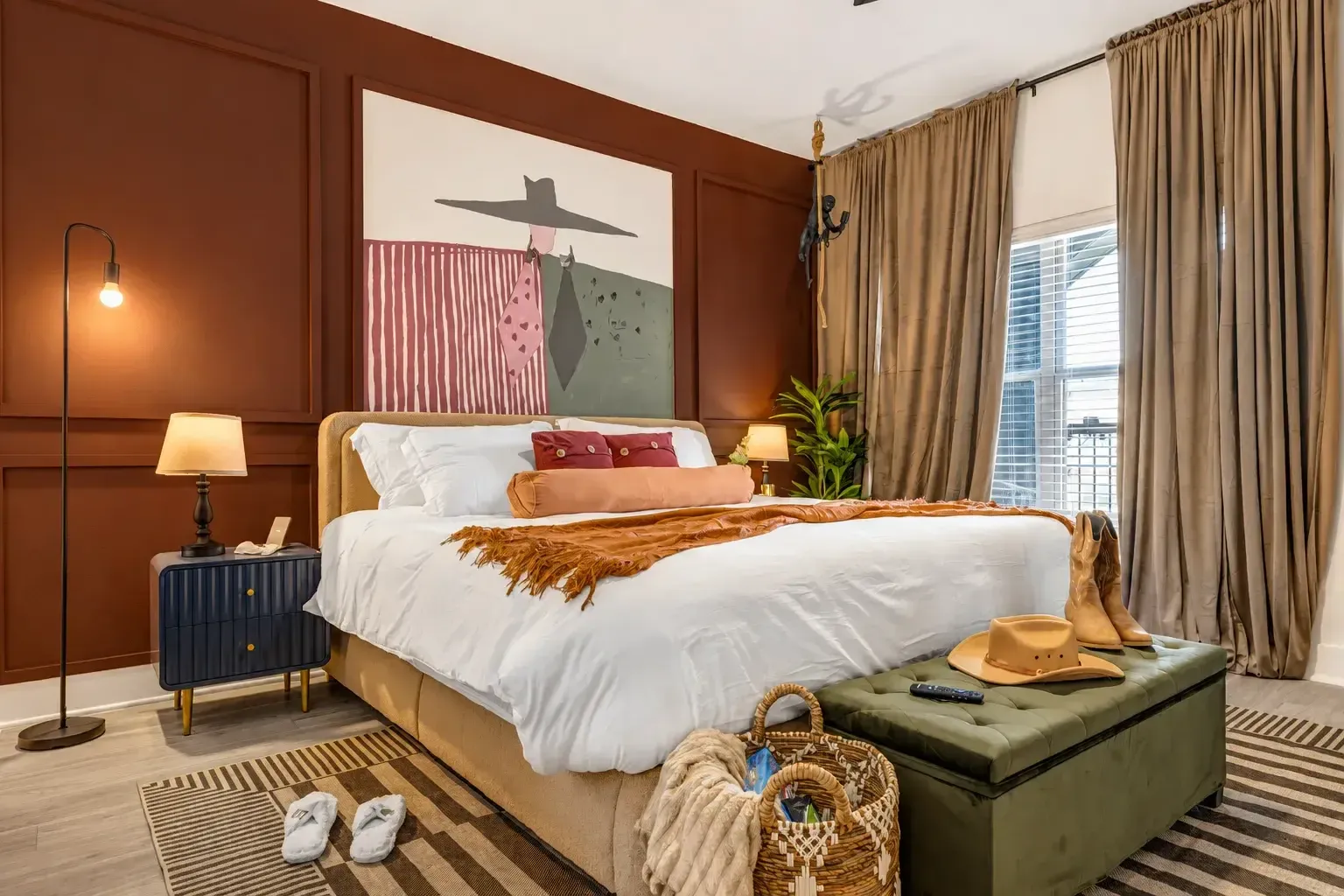 Bedroom with upholstered bench and warm accent wall