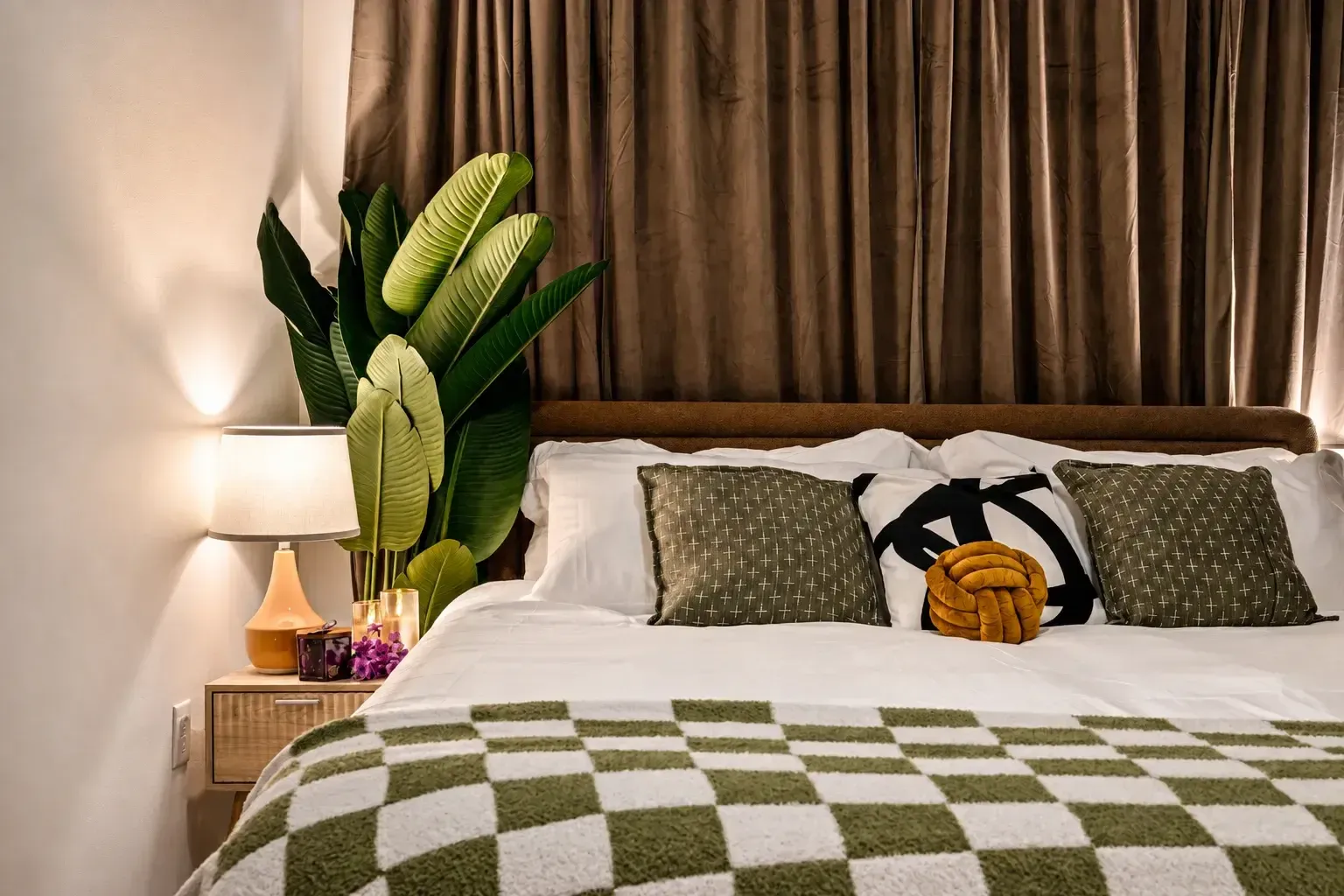 King bedroom with plants and layered bedding