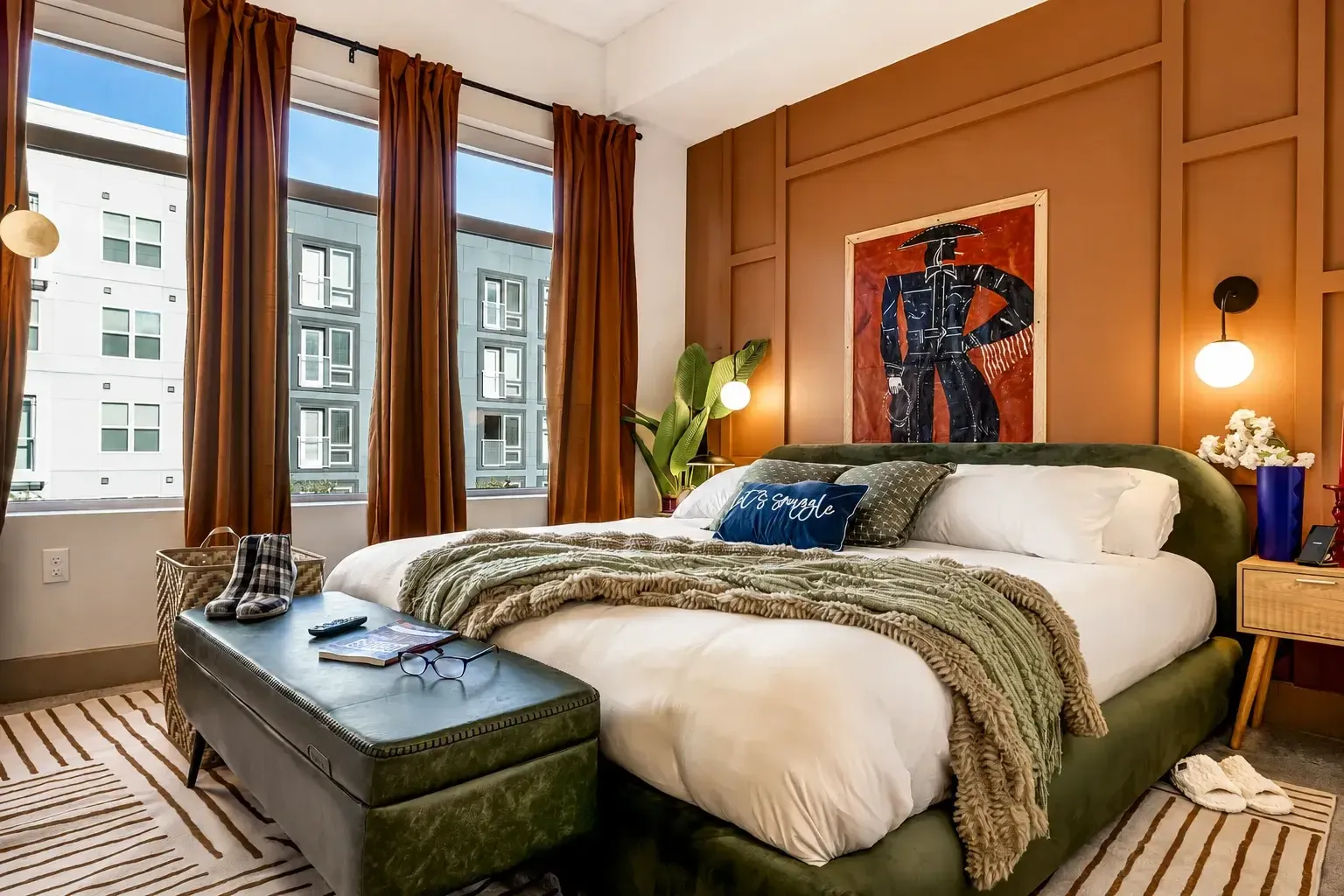 King bedroom with tall windows and warm lighting